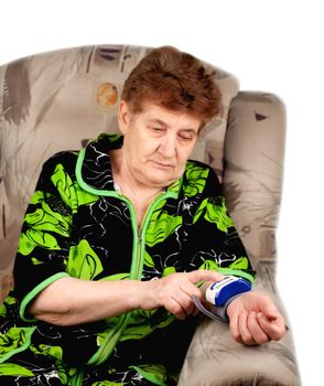 An elderly woman sitting in a chair, a medical household appliance measures the pressure exerted