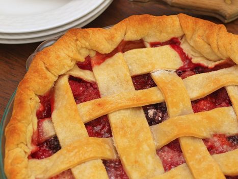 Fresh Baked Three-Berry Pie with Lattice Crust with Plates and Knife