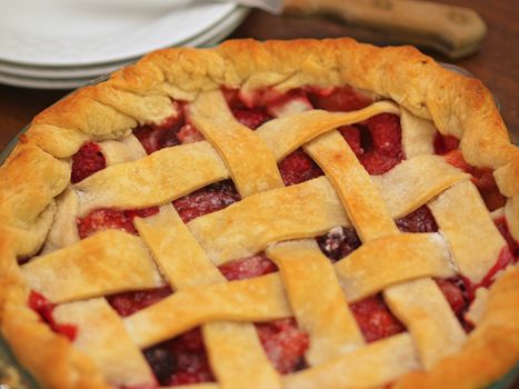 Fresh Baked Three-Berry Pie with Lattice Crust with Plates and Knife