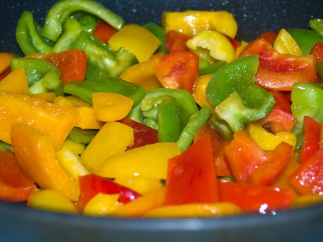 Frying red, green and yellow bell peppers