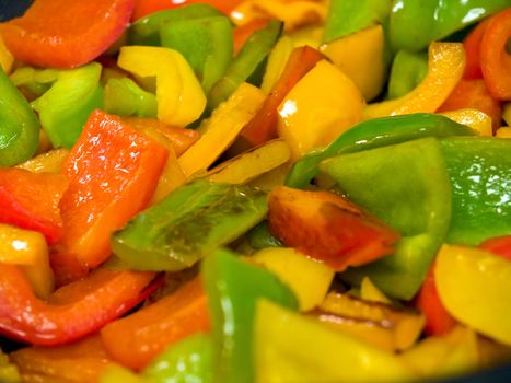 Frying red, green and yellow bell peppers