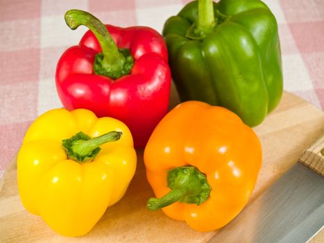 Bell Peppers on a Wooden Cutting Board with Knife