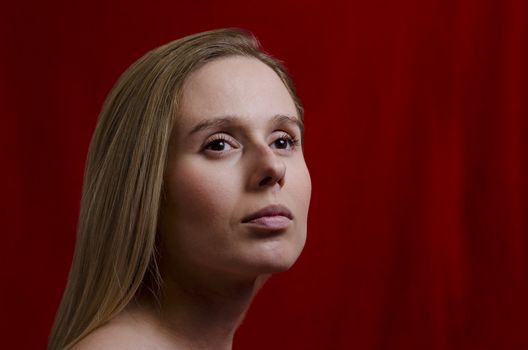 portrait of a young blonde woman on red background