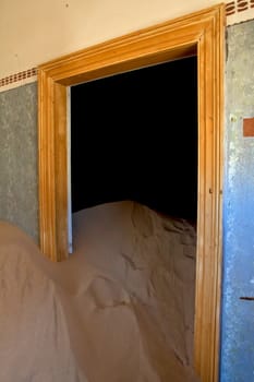 a dune coming from a door in a house at kolmanskop ghost town namibia africa 