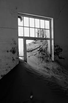 a dune coming from a window in a house at kolmanskop ghost town namibia africa 