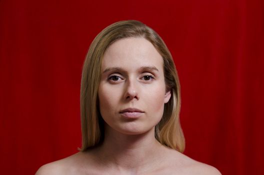 portrait of a young blonde woman on red background