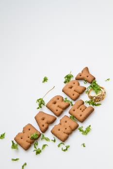 Marry me wording by brown biscuits with green leaves on white surface in portrait orientation