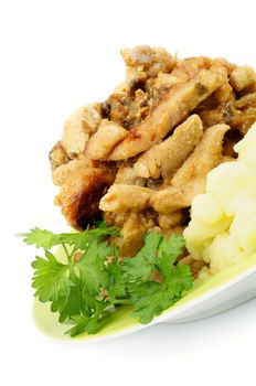 Traditional Russian Dish: Beef Stroganoff. Delicious Baked Beef with Mushrooms and Sauce, Mashed Potato and Greens on Yellow Plate closeup