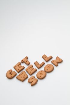 Slanting get well soon wording made by brown biscuits on white surface portrait orientation