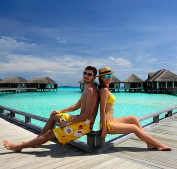 Couple on a tropical beach jetty at Maldives