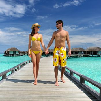 Couple on a tropical beach jetty at Maldives