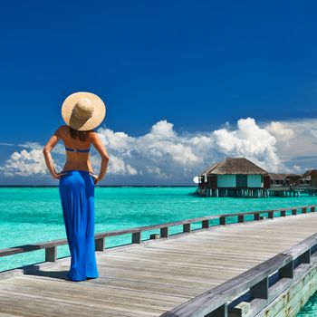 Woman on a tropical beach jetty at Maldives