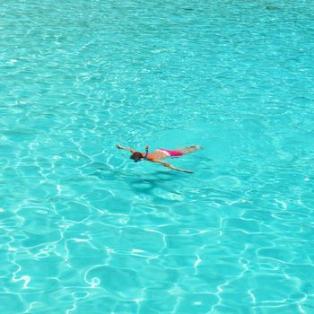 Man snorkeling in crystal clear turquoise water at tropical beach