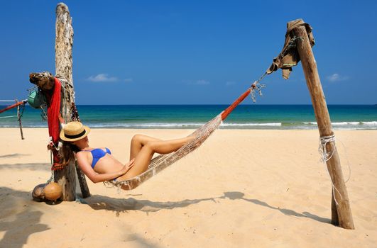 Woman in hammock on tropical beach at Tioman island, Malaysia