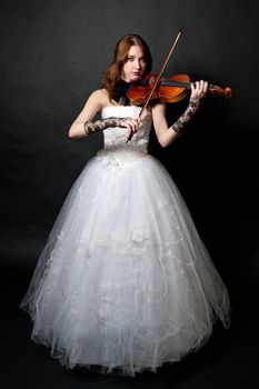 Girl in white dress with violin on black background