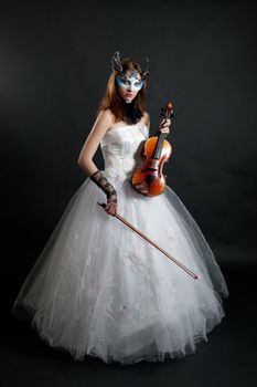 Girl in white dress and mask with violin on black background