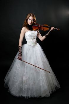 Girl in white dress with violin on black background
