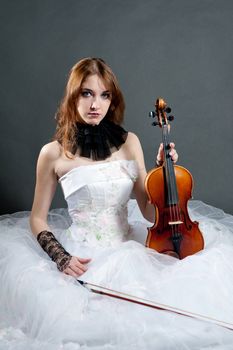 Girl in white dress with violin on black background