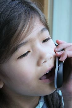 Six year old girl talking on cell phone.;