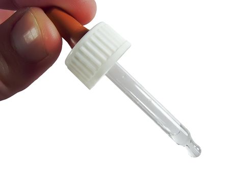 a dropper between finger and a thumb over white