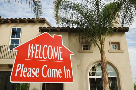 Welcome, Please Come In Real Estate Sign in Front of New Home