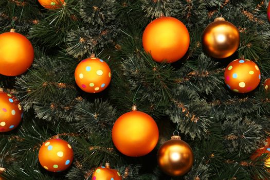 cropped shot of a christmas tree dotted with golden colored balls