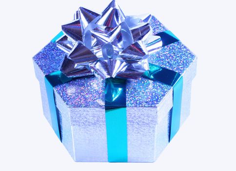 Silver sparkling gift box tied with green satin ribbon and silver bow, isolated on white.