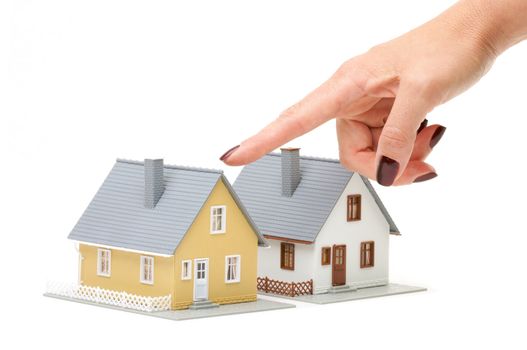 Female hand pointing at a house isolated on a white background.