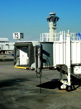 Jetway at an airport with control tower in the background.