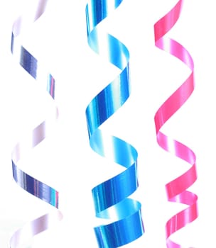 Shiny colorful satin ribbons hanging in curls. Holiday, celebration, party theme.