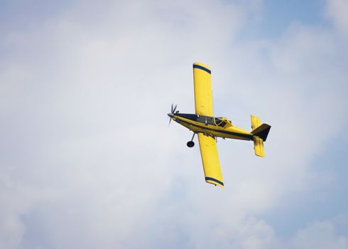 Yellow Crop Duster against ablue sky