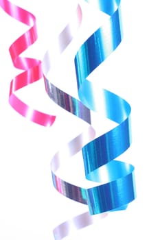 Shiny colorful satin ribbons hanging in curls. Holiday, celebration, party theme.