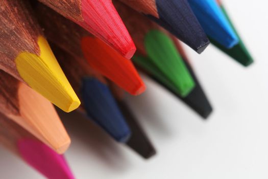 A macro shot of the front end of a group of colored pencils, isolated on white