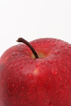 A close up of a red apple isolated on white, water drops on apple