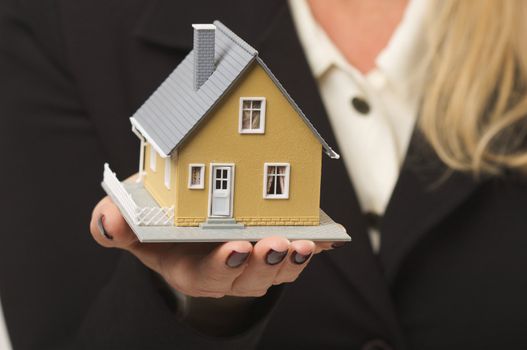 Female hand holding small house.