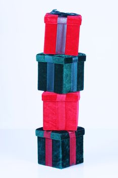 Red and green presents stacked on top of one another on white background.
