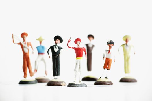 Whimsical mexican clay toy cowboys on a white background.