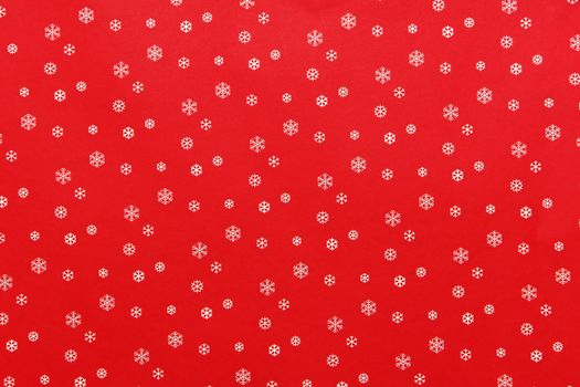 A close up of a paper with snowflakes on red background