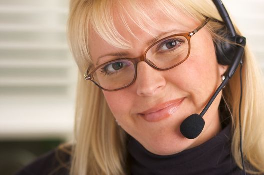 Attractive businesswoman talks on her phone headset.