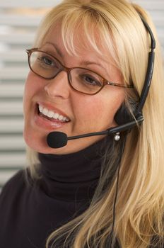 Attractive businesswoman talks on her phone headset.