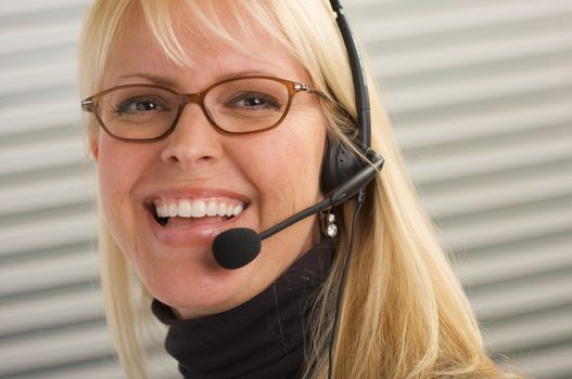 Attractive businesswoman talks on her phone headset.