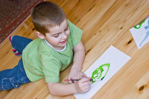 a boy is painting on the floor