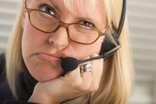 Attractive businesswoman talks on her phone headset.