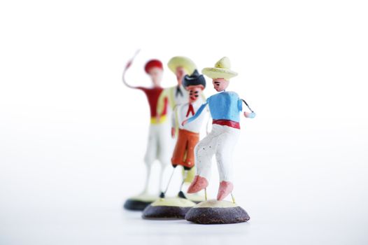 Whimsical mexican clay toy cowboys on a white background.