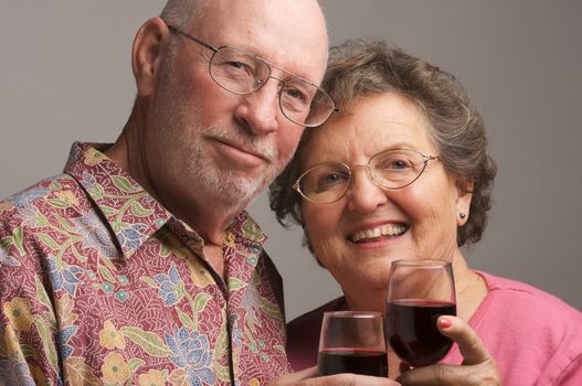 Happy Senior Couple toasting with Winee glasses.