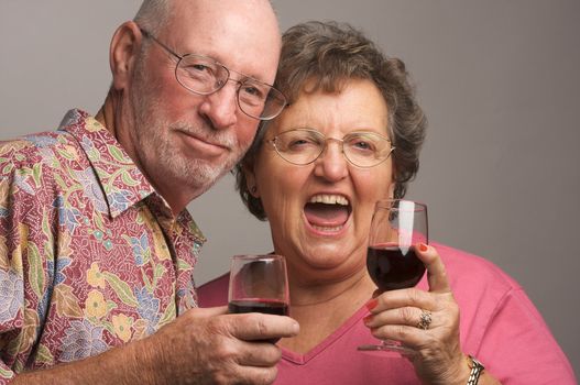 Happy Senior Couple toasting with Winee glasses.