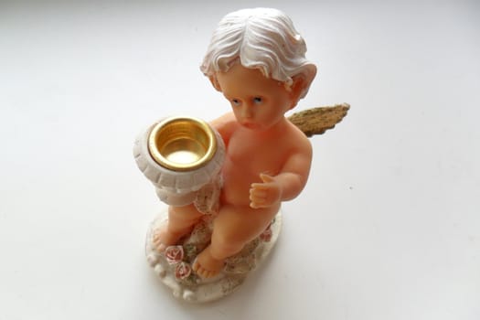 Porcelain candle holder in the form of a
cupid