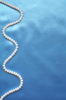 Pearls on the smooth elegant blue silk can use as background