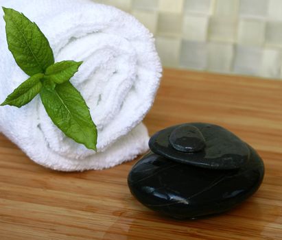 White bath towel and black stones in spa composition