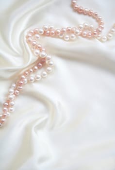 Smooth elegant white silk with white and pink pearls can use as wedding background 
